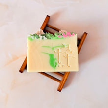 Cargar imagen en el visor de la galería, Jabonera de bambú en tono oscuro con barra artesanal de Tt atelier sobre fondo mármol claro.