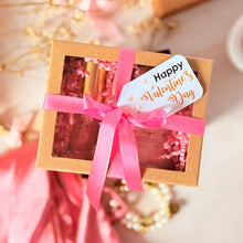 Cargar imagen en el visor de la galería, Caja de regalo artesanal con scrub corporal y lip gloss, decorada con lazo rosa y tag de San Valentín.