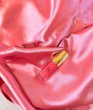 Cargar imagen en el visor de la galería, Lip Gloss Pink Bliss (02) con tapa dorada sobre tela satinada rosa – Tt atelier
