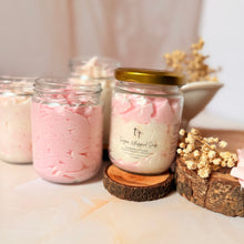 Cargar imagen en el visor de la galería, Exfoliantes corporales Pink Mimosa en frascos con tapa dorada, acompañados de accesorios de flores secas sobre fondo rosa suave. Presentación elegante y artesanal.