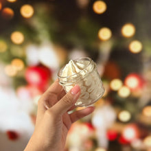 Cargar imagen en el visor de la galería, Whipped body butter navideño en frasco de cristal, textura batida y fondo de luces cálidas.
