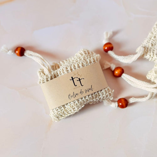 Bolsa de sisal artesanal con cordón de madera y etiqueta de Tt atelier sobre fondo neutro.