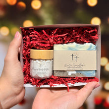 Cargar imagen en el visor de la galería, Caja abierta sostenida con dos manos, en su interior una barra de jabón de colección y una mini whipped body butter.
